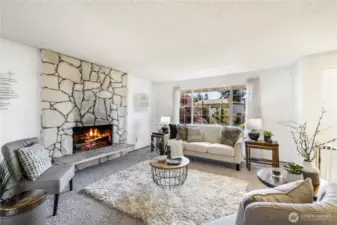 The living room is spacious and light-filled, with a wood-burning fireplace offering warmth in cool winter months.