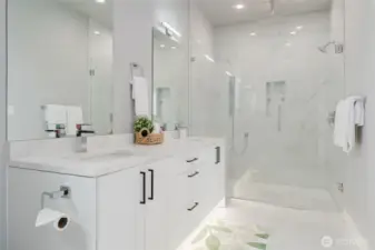 Primary bathroom includes large double vanity and tiled walk in shower