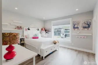 Second upstairs bedroom with tall ceilings and large window