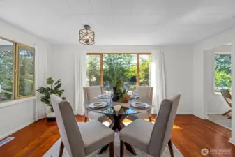 Gather with friends and family in the light-filled dining area—surrounded by windows that frame the lush greenery outside.
