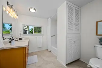 Spacious and updated, the main floor bathroom features double sinks, modern lighting, and a combination tub and shower for convenience.