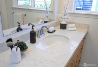 Bright and inviting bathroom vanity with sleek brushed-nickel fixtures and polished quartz countertop.