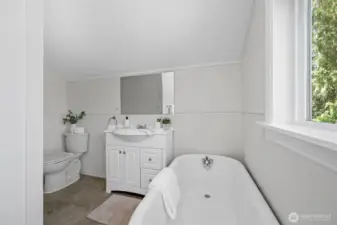 Relax and unwind in the vintage-style upstairs bathroom, complete with a classic clawfoot tub and a view of the trees outside.