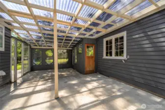 Covered patio with corrugated roofing lets you enjoy fresh air rain or shine.