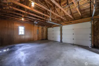 Oversized two-car garage with vaulted ceilings and workbench space—ideal for projects, storage, or hobbies.