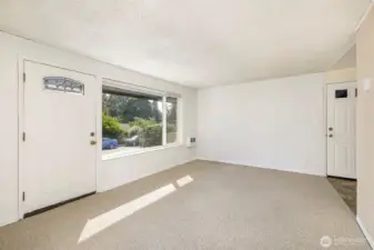 Bright entry & living area in home. Door on right is to carport entrance