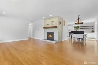 Home features an open floor-plan with woodburning fireplace, brick surround and wood mantel.