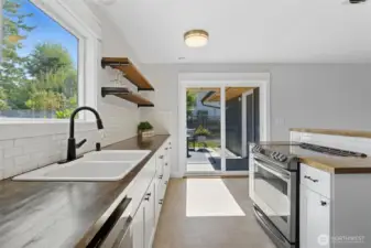 Nicely updated kitchen with white cabinetry and subway tiles. Slider to patio.