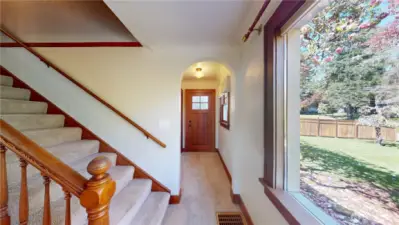 From living room looking past stairs to side entrance