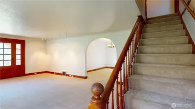 Base of stairs looking towards the living room & dining room.  Old world charm as you walk the banister up to the second floor.