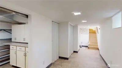Downstairs basement looking towards stairs.  There is loads of storage here and areas for crafts, canning etc. There is a half bath near the stairs, furnace and hotwater heater are off to the left behind corrigated doors.  this home has an energy efficient heat pump and newer hot water heater.  The stairs lead up to the kitchen and there is a landing where the door to the back yard is.