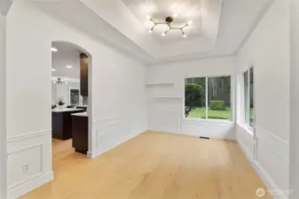 Spacious formal dining area with coffered ceilings and wainscoting.