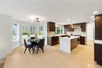 Gourmet kitchen featuring brand-new cabinetry with an abundance of thoughtful storage and built-in features. Enjoy upgraded appliances—all included—highlighted by a sleek European-style gas range and designer hood fan. The spacious island offers a convenient microwave/convection oven combo, perfect for modern living. A full tile backsplash adds a touch of elegance, tying the entire space together. This kitchen truly blends style, function, and high-end finishes—plus so much more to discover!