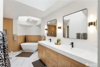 A beautifully designed contemporary bathroom with a double-sink vanity, warm wood finishes, elegant black hardware, and a luxurious freestanding tub—perfect for a relaxing, spa-like retreat.