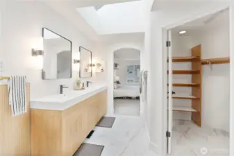 Tastefully remodeled primary bathroom with double sink vanity, separate shower and soaking tub, walk-in closet, & skylights.