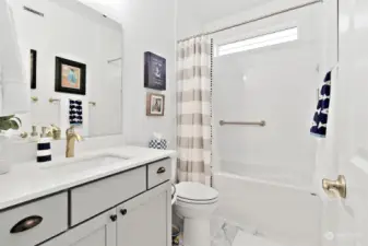 The guest bath is lovely with the tiled bathtub, porcelain tile flooring, & Quartz counters. Lots of storage here, too!