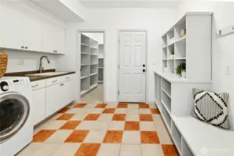 Winding back around the kitchen you find  the roomy laundry room/mud-room with amazing cabinetry storage, ample shelving and a handy sink too.