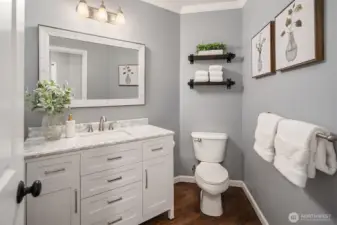 The main-level half bath features a marble countertop vanity, elegant finishes, and thoughtful design for guests’ comfort.