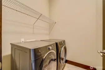 Large utility room features a newer washer and dryer.