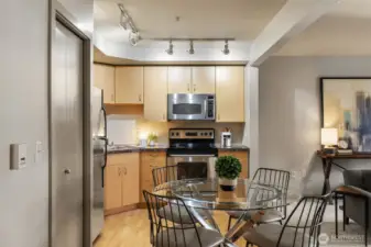 Laundry closet, deco tile backsplash, cable lighting, and plenty of cabinetry.