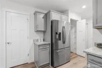 This door has under-stair access for added storage. To the right of the fridge is a pantry, who doesn't love that?