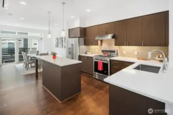 The large kitchen features a gas stove and tile backsplash.