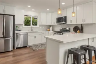 Full height cabinets, quartz counters and soft-close hardware along with a lovely tiled backsplash.