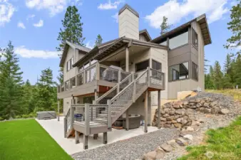 Great view of the main floor deck with stairs to the yard, patio on yard level, artificial turf  for easy care and great place for yard sports and then the hot tub ready for a relaxing dip.