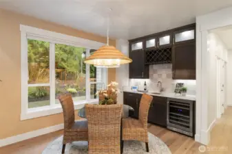 Dining area with wine/coffee bar and lighted cabinets.