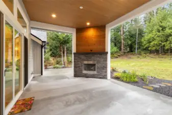 Covered patio off living room with fireplace.