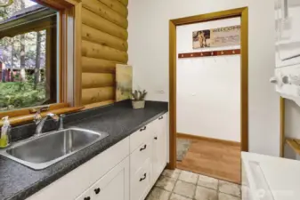 Utility room off of back door with an attached half bath.