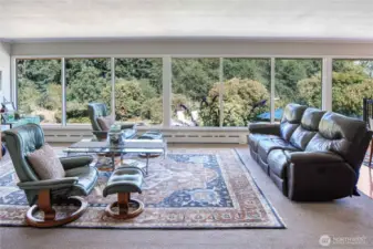 Floor to ceiling wall of windows welcomes you home and offers beautiful year-round views of your private backyard gardens.