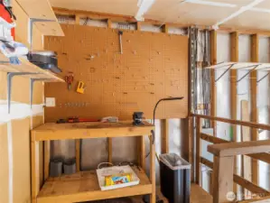 Large garage complete with workbench and ample storage space.