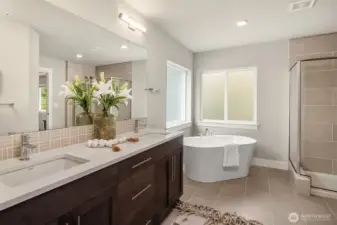 Spacious primary bath with spa like soaking tub, separate tile shower, double sink vanity and water closet.
