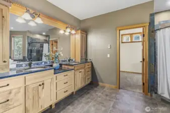 Primary bathroom has floor heating and Stone Countertops with Custom Wood Cabinets