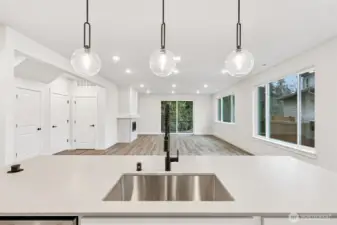 Wow, just wow.  Gorgeous quartz counter slabs throughout; undermount single basin sink with upgraded spring faucet.  Popup outlet at counter, GE appliances and large walk-in pantry.