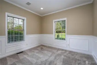 Office on the main level features wainscoting and a custom bookcase with great storage. The bookcase has adjustable shelves.