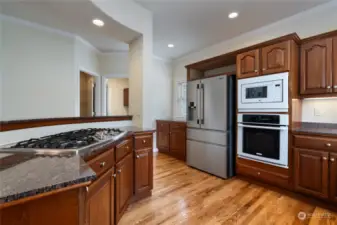 The open concept kitchen features granite countertops throughout, an island, stainless steel dishwasher, stainless steel stovetop and a brand new stainless steel Frigidaire Professional refrigerator that was replaced in 2024. There is room for 4 barstools at the island.