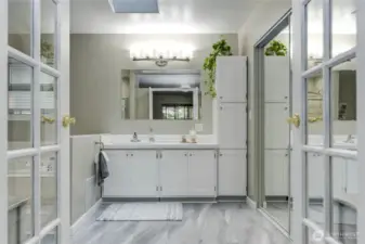 Large primary bathroom with walk-in closet with mirror closet doors.