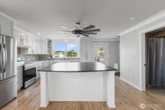 Closer kitchen view showing Giant Granite top island, all new appliances stay! Back door to private deck. Walk in pantry to right.