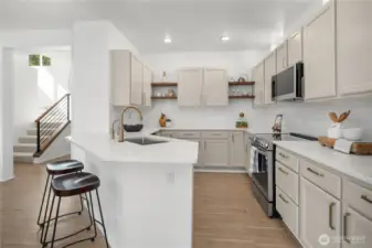 The kitchen features quarts counters, premium hardware, new appliances and solid wood open shelves