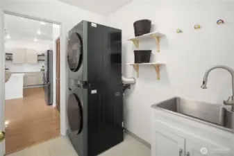 This laundry room was renovated in 2024 and features beautiful tile, new washer/dryer and a handy utility sink