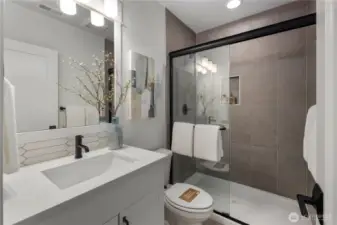 Main Floor Bath: Stylish full bath features modern tile, quartz counters, and a glass-enclosed shower. Conveniently located near the main-level den or guest bedroom for added privacy and comfort.    Photos are from THIS model home at Foxmoore but are for visualization purposes only.  Photos are from the model home at Foxmoore and for visualization purposes only. Plans, colors, building orientation, finishes, home outlook, and other details can and WILL vary.