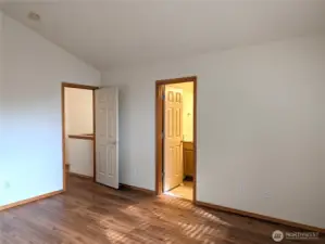 Primary Bedroom with vaulted ceilings. Entry door and door to primary bath