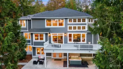 Back exterior of the home with a large deck and lower patio.