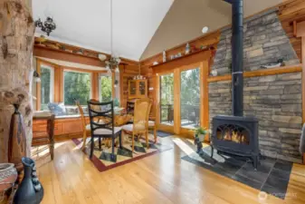 Dining room with wood burning stove & vaulted ceiling.