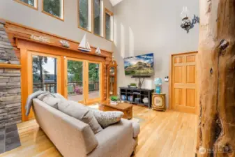 Living room with water view, vaulted ceiling and beautiful log pillars. Walks out onto wrap-around trex deck.