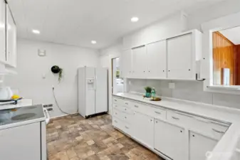 View of the kitchen and the solarium off to the right in the photo. Plenty of counterspace for meal prep.