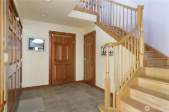 Enter into the foyer with 2 story ceiling and beautiful open wood staircase.  Door in middle leads to huge 3 car garage