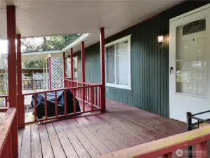 The deck is covered and there is wall mounted lighting on both sides of the house.